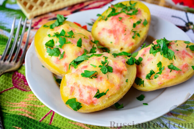 Запечённый картофель, фаршированный сыром и колбасой, готовится очень просто и из простых продуктов, но результат превзойдет ваши ожидания - блюдо очень аппетитное и вкусное. Подготовим продукты. Картошку предварительно сварим в мундире. Отварную картошку разрежем пополам. Сыр и колбасу натрем на терке. Из половинок картофеля аккуратно удалим внутреннюю часть чайной ложкой. Смешаем мякоть картофеля с сыром и колбасой. Добавим соль и перец по вкусу. Добавим сметану и перемешаем начинку. Наполним половинки картофеля приготовленной начинкой. Форму для запекания смажем растительным или сливочным маслом. Выложим в форму фаршированную картошку с сыром и колбасой и поставим в духовку, разогретую до 200 градусов. Готовый запеченный картофель украсим свежей зеленью. Аппетитный картофель, фаршированный сыром и колбасой, украсит ваш стол и сделает семейный обед очень вкусным. Приятного аппетита!