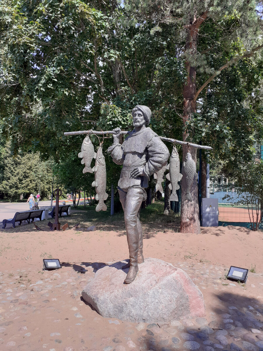 Скульптура рыбака в парке.