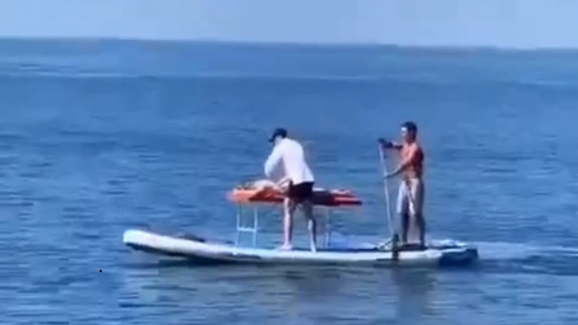     Отдыхающие на пляже в Сочи заметили в Черном море у берега плавучий массажный кабинет. Для этого неизвестный массажист установил прямо на сапборде массажный стол, на котором принял как минимум одного посетителя. Еще один человек с помощью весла управлял плавсредством.