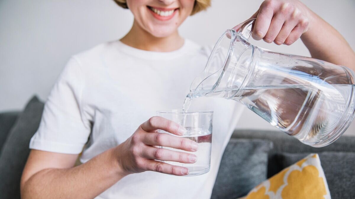    Девушка наливает воду из графина© Фото : Freepik