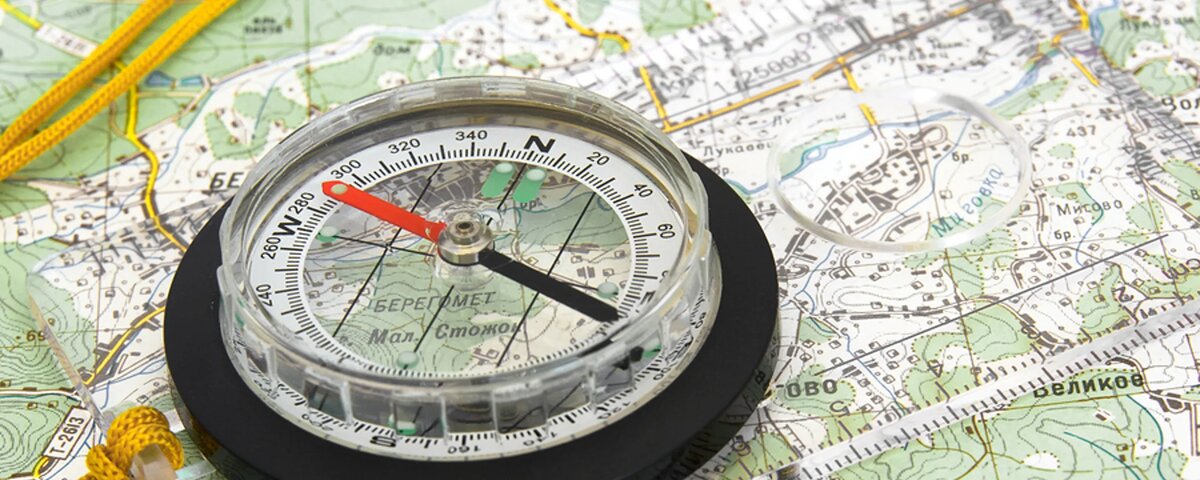 стрелка представляет собой магнит, где южный и северный полюсы промаркированы цветом. чаще красный - указывает на юг. но лучше проверить, например по Солнцу. простейший ориентир - восход на востоке, закат на западе.