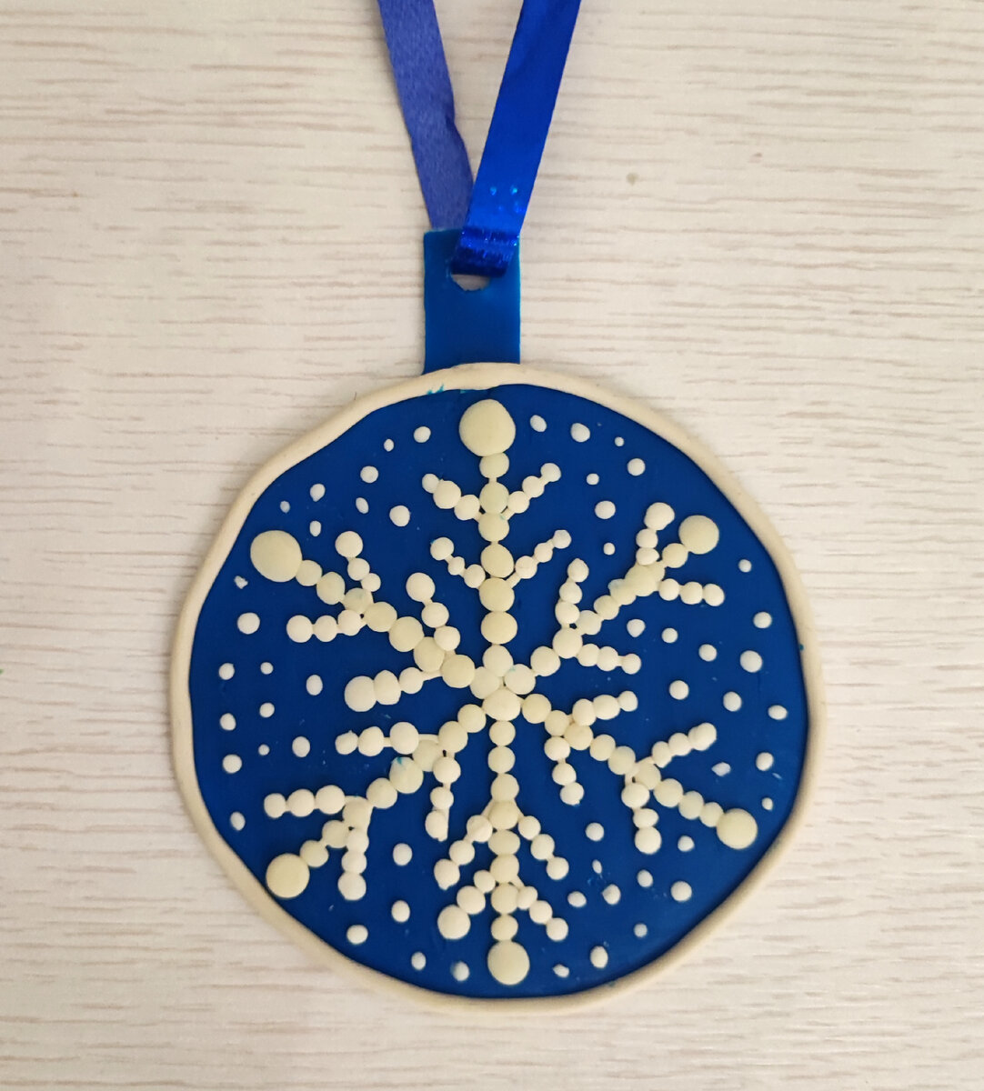 Готовый вариант поделки из пластилина на картоне "Снежинка".