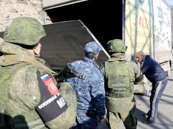 Армянский полицай выглядывает из-за чужой спины