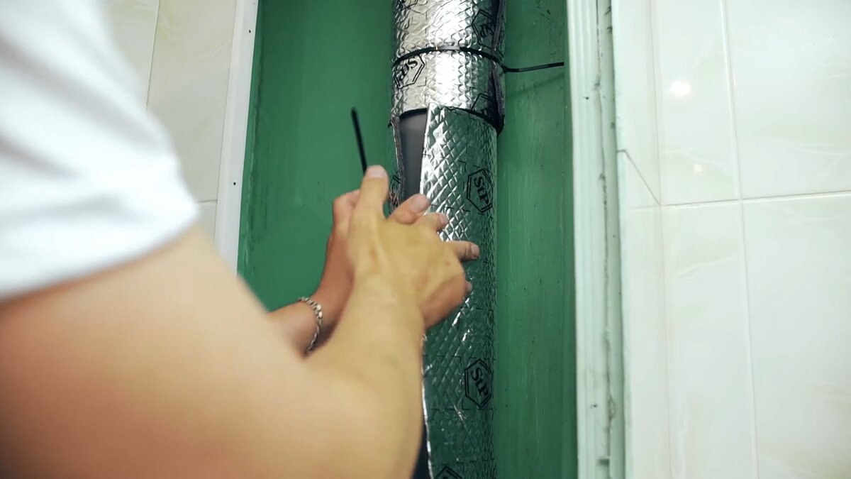 Оборачиваем трубу звукоизоляцией, закреплем листы стяжкками.