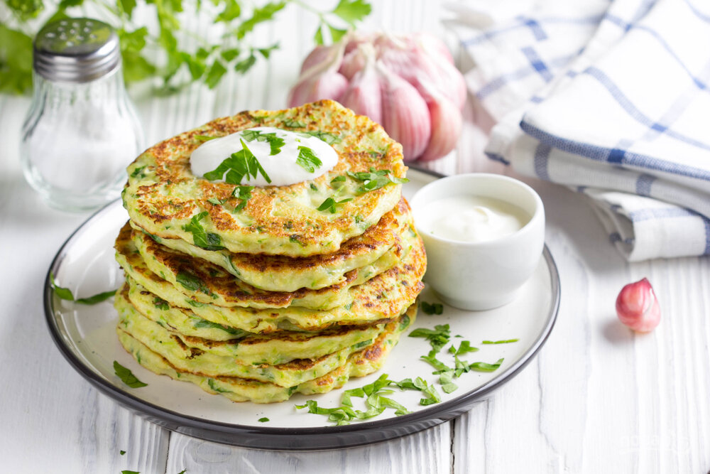 Кабачковые оладьи подавайте с зеленью и сметаной