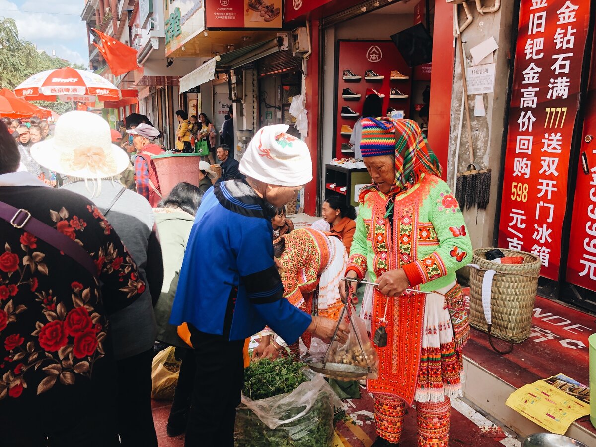 У торговли нет национальных границ: покупательница народности булан покупает имбирь у продавщицы лаху. Обратите внимание на ручные весы!