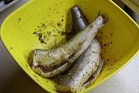 Сперва следует зачистить рыбу от внутренностей и чешуи. Промыть тушки и замариновать в смеси растительного масла, специй, лимонного сока и соли. Оставить рыбу мариноваться на десять минут.