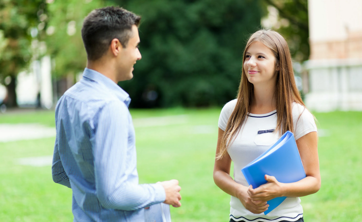 Молодежь читает книги. Подросток улыбается. Учащиеся студенты. Студентки возле вуза. Два студента разговаривают.