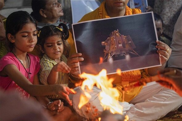 Люди совершают молитву за безопасную посадку космического корабля «Чандраян-3» на Луну. Нью-Дели, Индия, 23 августа 2023 года (Фото: Adnan Abidi / Reuters).