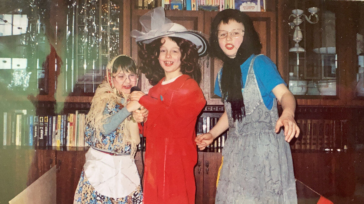 Это была какая-то нудная осень. И мальчишки показывали мне концерт. Нарядились, губы во накрасили. В красной блузке, превратившейся в платье-балахон, и почти рыжем парике, как вы понимаете, это Алла Пугачёва. А две очкастые актрисы - это Матрёна и Цветочек. И это просто обычный осенний вечер. А я сижу на диване напротив, концерт смотрю и аплодирую. 