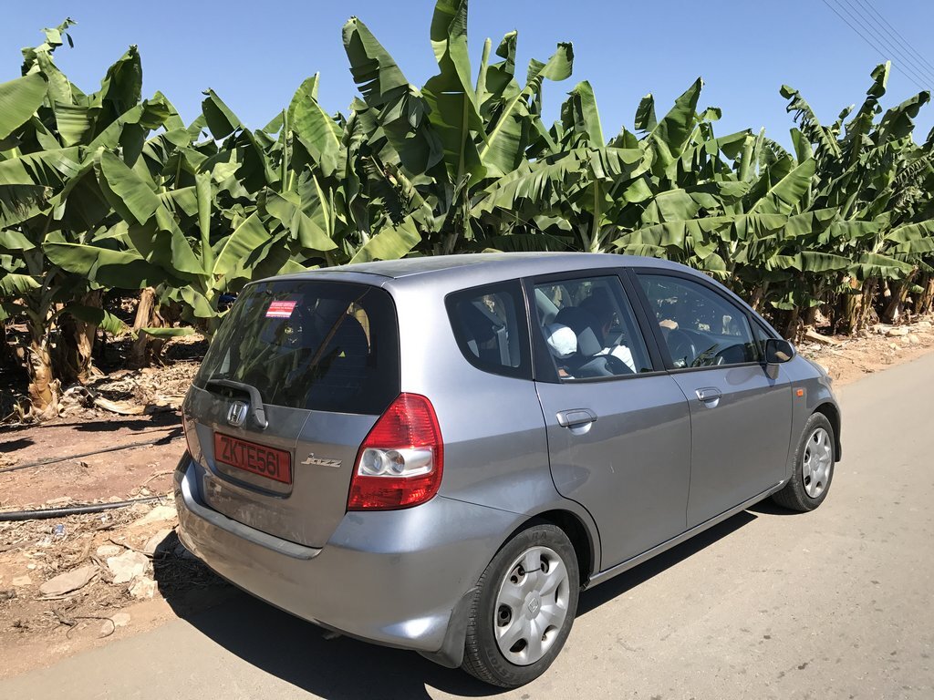 С включенным на максимум кондиционером и четырьмя пассажирами на борту 83-сильная Honda Jazz с большим трудом брала подъемы близ города Полис, но в целом хэтчбек произвёл впечатление добротного автомобиля. Стоимость 3-дневной аренды машины в местной кипрской конторе составляла 100 евро. На заднем плане - банановое поле.   