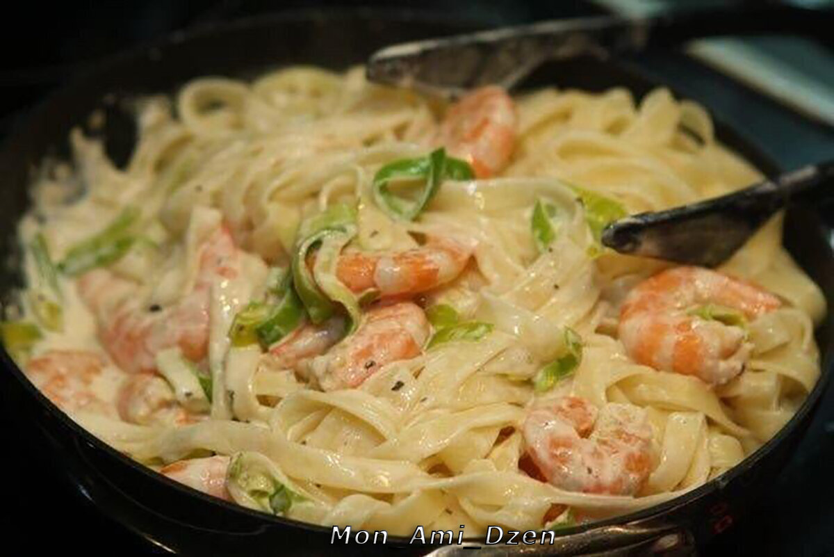 Добавьте креветки и обжарьте в течение 2 минут. Залейте сметаной и тертым сыром.