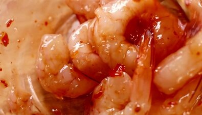 Основным ингредиентом в нашем салате будут креветки, поэтому их выбор будет немаловажным этапом. Лучше брать королевские, хотя маленькие более ароматные. Их можно отваривать, но мы в нашем случае креветки обжарим, а предварительно немного промаринуем. Для этого в глубокую посудину наливаем сладкий соус чили и опускаем туда очищенные креветки, перемешиваем и оставляем мариноваться не менее, чем на полчаса.