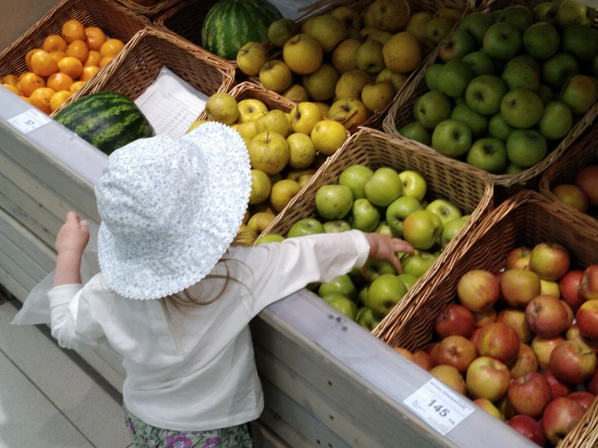 Начинаем с малого: "Купим желтые яблоки или зеленые?" Ребенок выбирает и сам складывает яблоки в пакет. Одновременно можно потренировать счет: "Положи 5 яблок".
