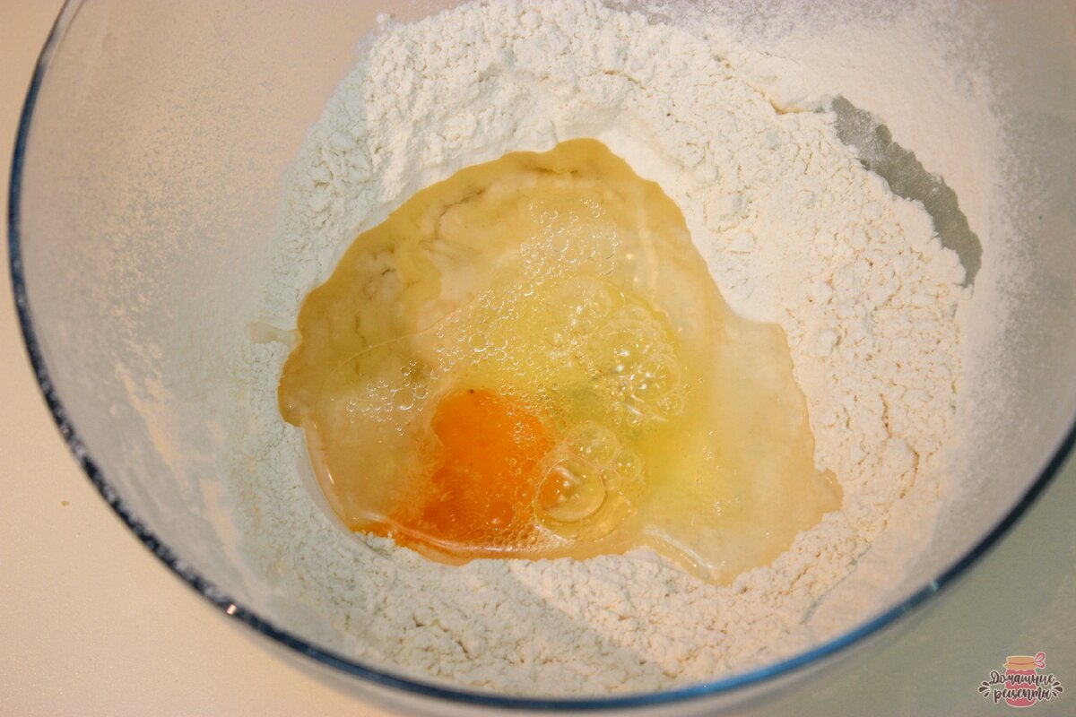 Приготовим вытяжное тесто. Муку просеять, добавить соль, перемешать. В муке делаем небольшое углубление, добавляем яйцо, масло и тёплую воду.