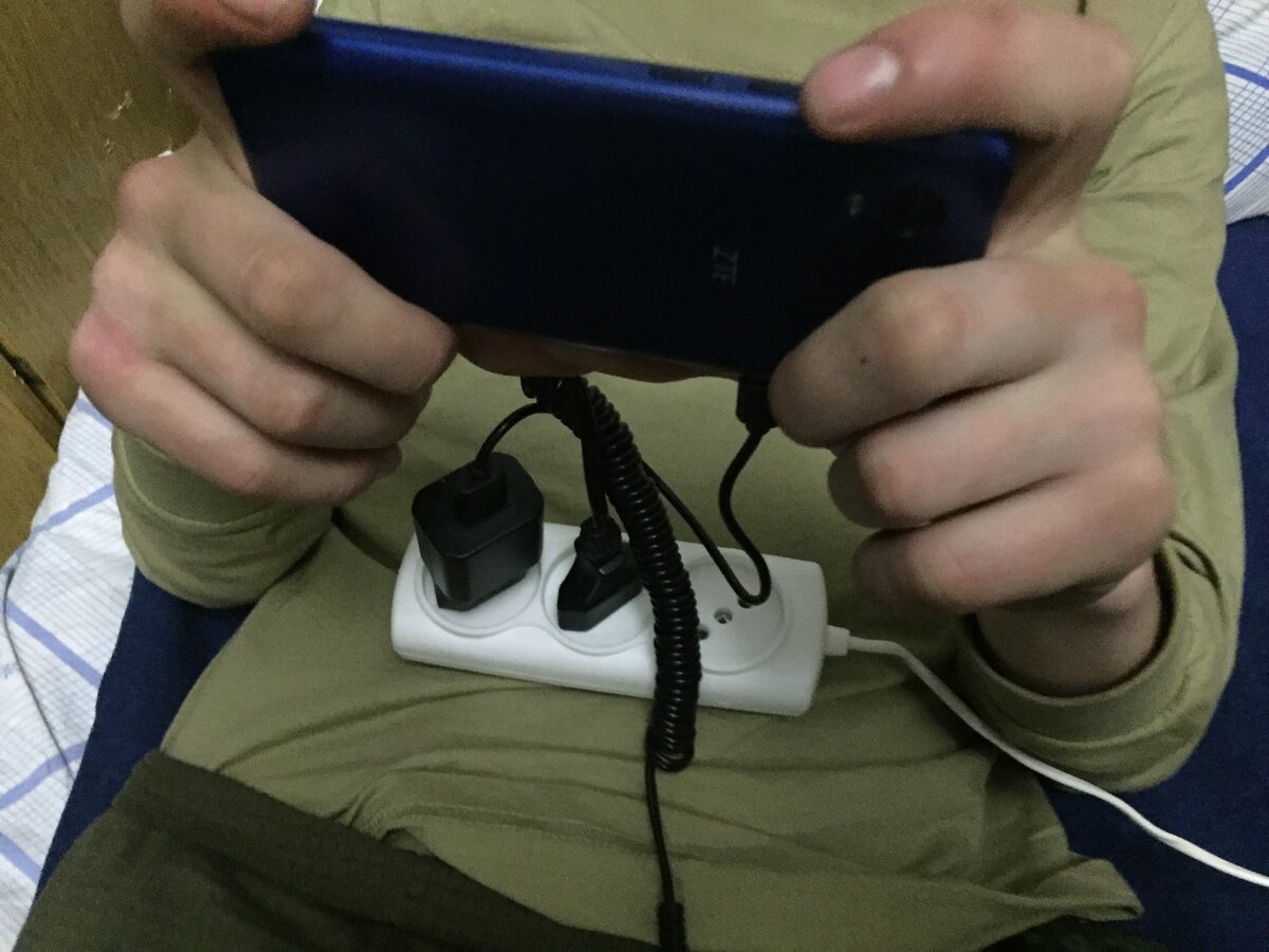 На фото: Боец контрактник отдыхает со смартфоном в расположении. Однозначно нарушение и не одно....