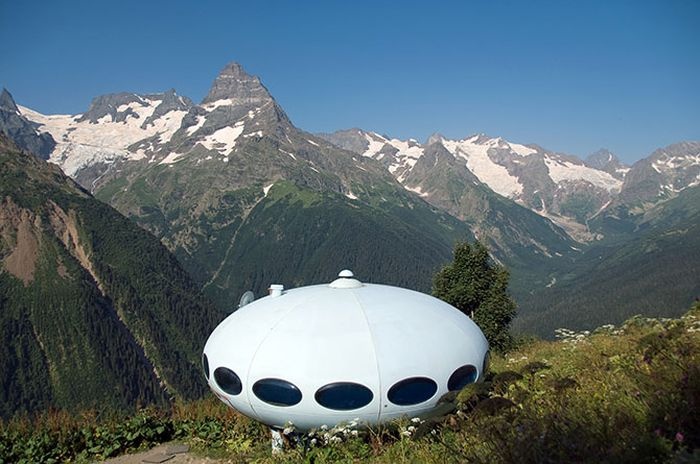 Гостиница «Тарелка», Домбай, Россия Построена в 1969 году на склоне горы Мусса-Ачитара, на высоте 2250 метров над уровнем моря. Гостиницу можно перевозить: она разбирается на части либо целиком переносится с помощью вертолета. 
Источник: https://fishki.net/1216332-grandioznye-i-fantasticheskie-sooruzhenija-vremen-sssr.html/gallery-278168/ © Fishki.net