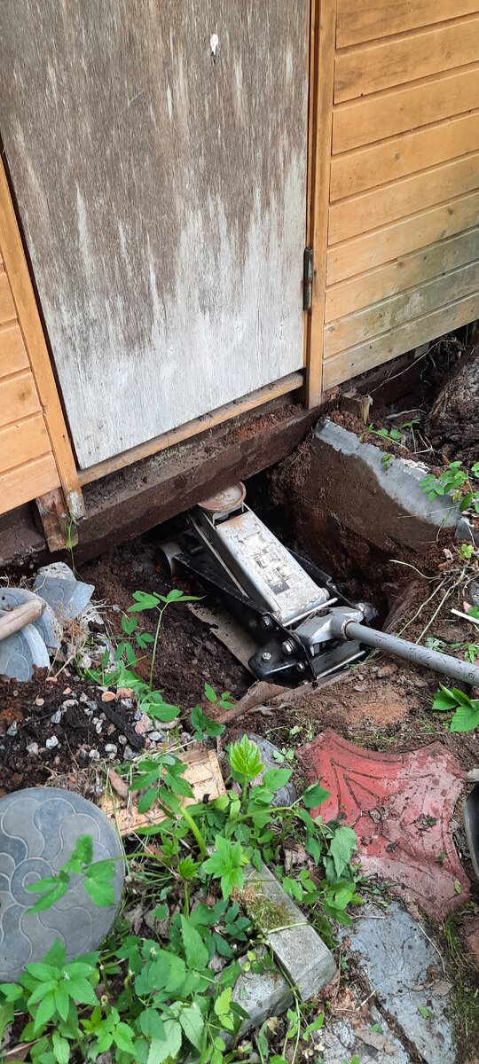 Поставили его на такой вот большой домкрат и приподняли. Тут как раз виден этот несчастный рельс, который был назван Виктором проржавевшим дном вагона и который спокойно выдержал поднятие всего этого хозяйства в воздух. Далее докопали на высоту бетонных блоков и выставили строение по уровню.