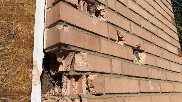 Посеченная осколками стена жилого дома.