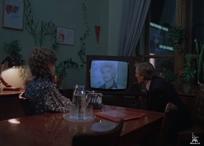 Здесь же мы видим, как пианист Рябинин падает на самое дно, а его респектабельная супруга по-прежнему — вещает из телеящика. / Скриншот экрана.