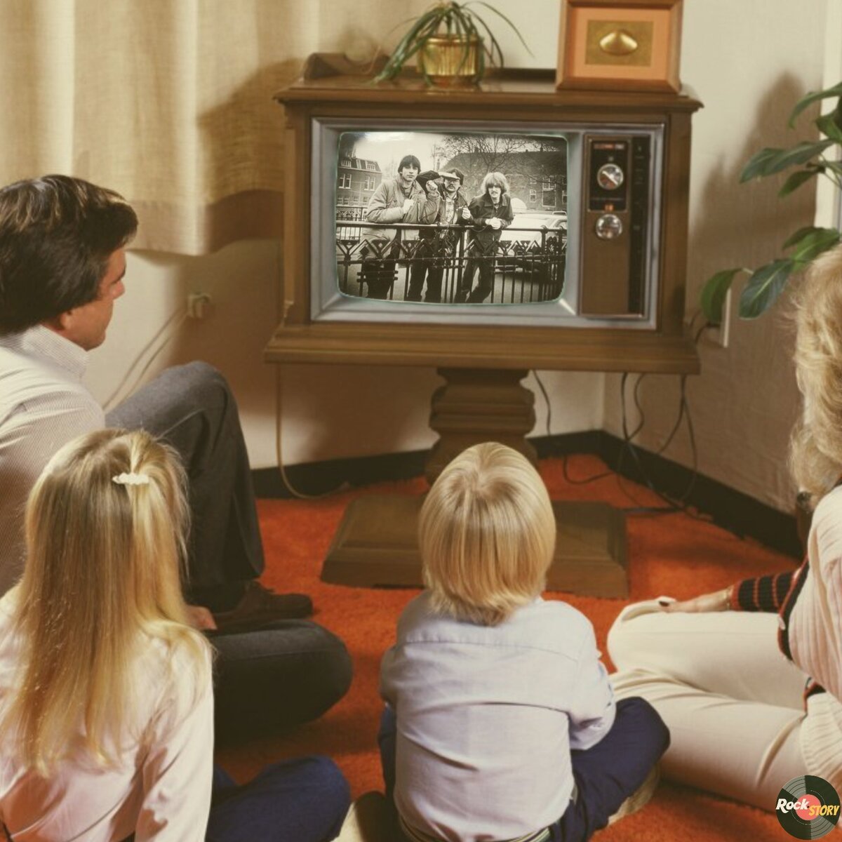 На фотографии: семья смотрит телевизор где показывают участников группы Peru, которые смотрят на семью 