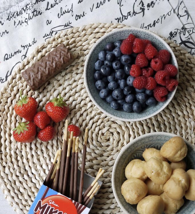 Ягоды, фрукты, любимые шоколадные батончики, или другие сладости ( на фото профитроли, в магазинах продают в замороженном виде). И главный ингредиент- соломка!