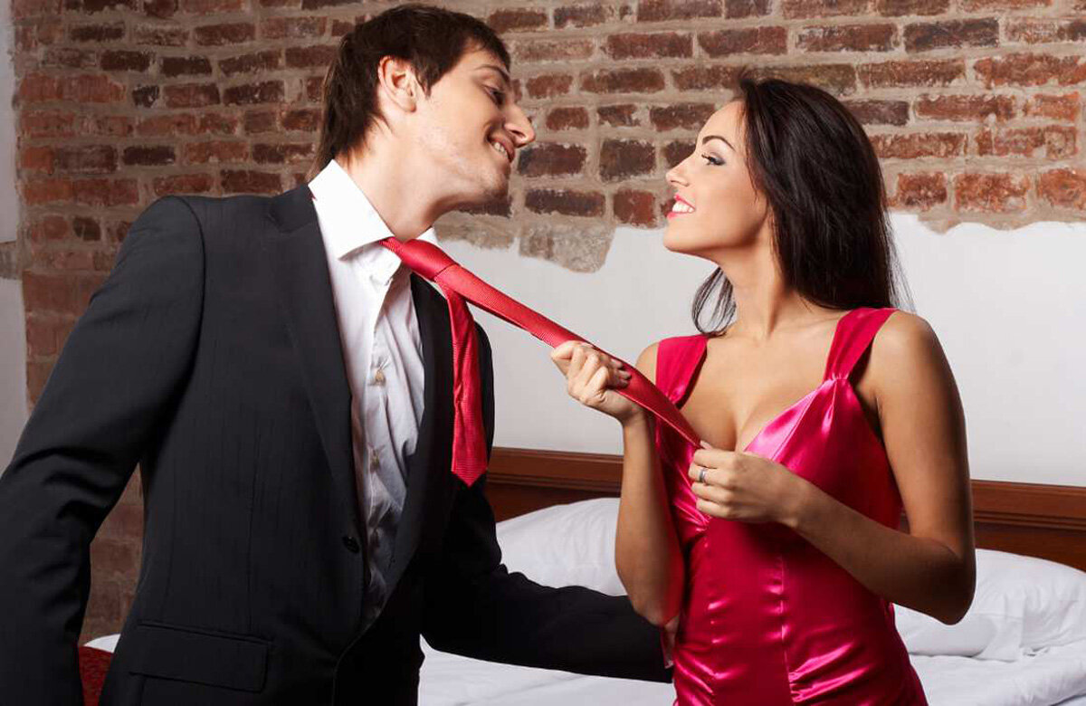 Женщина держит мужчину за галстук
