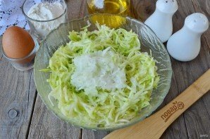 Кабачки натрите на крупной терке и отожмите сок. Добавьте к ним тертую луковицу, ее я тоже обычно тру на крупной терке. Перемешайте. 