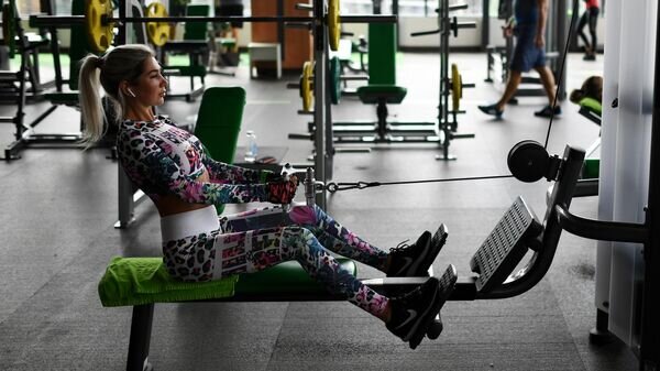    Девушка занимается на тренажере в фитнес-клубе© РИА Новости / Александр Кряжев