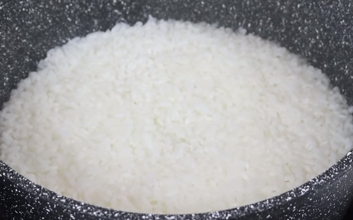 Как только рис закипел, убавить огонь до минимума, накрыть крышкой и готовить в течение 15 минут. По истечению 15 минут, кастрюлю снять с огня, укрыть полотенцем и закрыть крышкой, оставить еще на 15 минут.