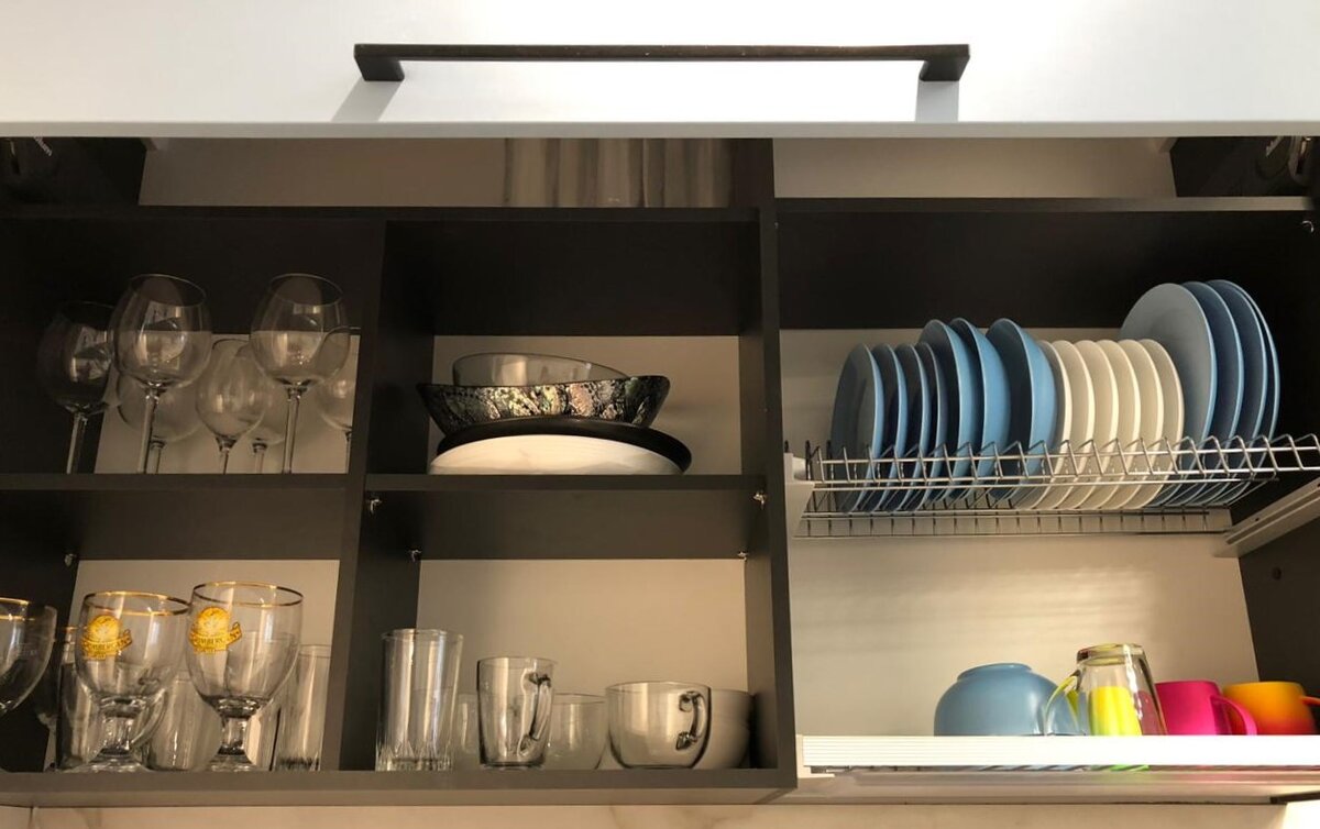 За общим фасадом со складным подъёмником спрятан целый посудный шкаф.