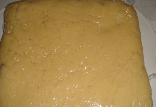     В неглубокую кастрюлю нарезаем произвольными кусочками сливочное масло или маргарин и ставим растапливаться на средний огонь. После этого снимаем кастрюлю с огня и вливаем молоко в масло. Только дождитесь, пока оно немного остынет, иначе молоко может свернуться (тем более, если оно не первой свежести).  Перемешиваем содержимое кастрюли при помощи миксера до образования однородной массы. Затем снова ставим на средний огонь и ждём, пока молочно-сливочная смесь загустеет. Для того чтобы не было комков, необходимо постоянно помешивать молоко.       Снимаем с огня. Берём 3 яйца и отделяем белки от желтков. Желтки добавляем в смесь. Тщательно перемешиваем.  Сыр (у меня российский) натираем на крупной тёрке и также высыпаем в кастрюлю, перемешиваем.       Итак, берём форму для выпечки, смазываем её сливочным маслом, выкладываем сырное тесто и отправляем в холодильник примерно на час (до тех пор, пока тесто полностью не застынет).       