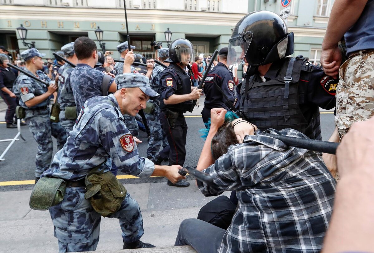 Задачи митингов. Полицейский бьет дубинкой.