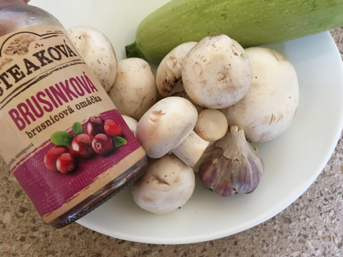 Ингредиенты: 
• молодой кабачок без жесткой кожуры и крупных семян – 400 г;
• шампиньоны – 100–120 г;
• брусничный соус – 20 мл;
• чеснок – 10–12 г;
• соль – 5–7 г.
Приготовление: 
Вымытый, но неочищенный кабачок нарезать дольками, как и грибы. Залить ягодным соусом. Переложить все это в толстостенную жаровню.