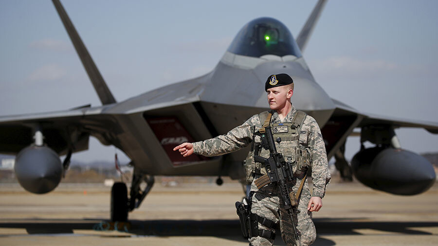 Солдат армии США стоит на страже перед истребителем-невидимкой F-22 на авиабазе Осан в Пхентхэке, Южная Корея. © Kim Hong-Ji / Reuters