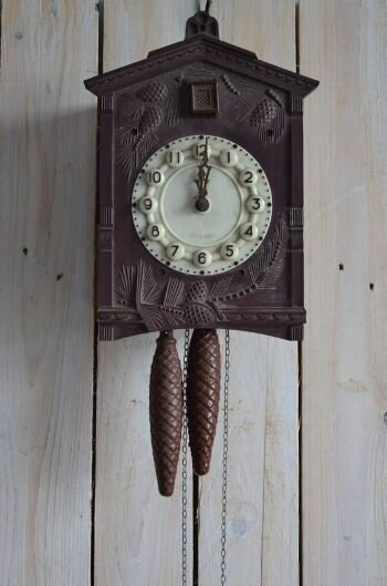 Такие часы по-английски назовут "a vintage cuckoo clock with cone-shaped weights"