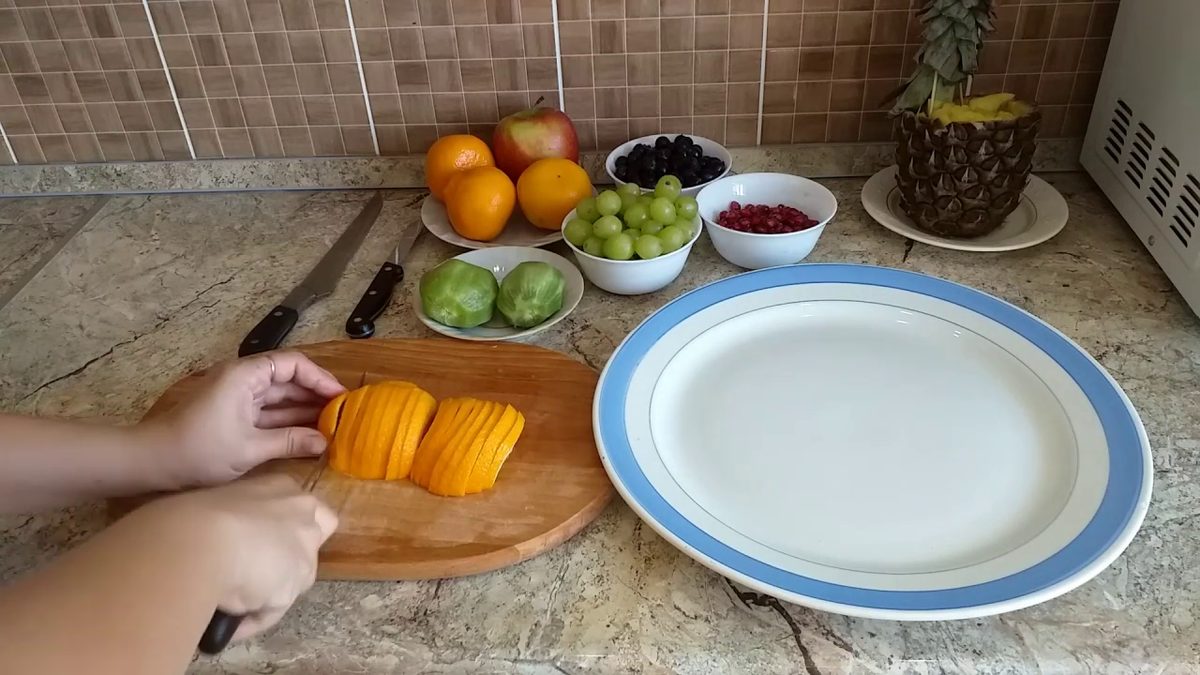 Апельсин делим пополам и режем на одинаковые дольки.