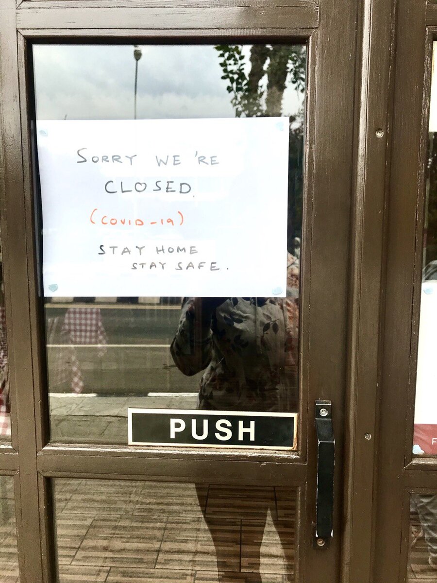 Надпись на дверях кафе " Извините, мы закрыты (коронавирус). Оставайтесь дома, оставайтесь в безопасности.»