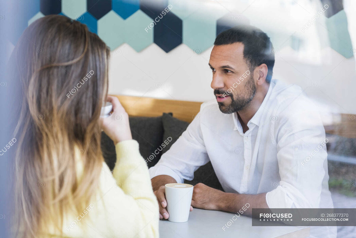 https://focusedcollection.com/ru/268377370/stock-photo-man-woman-sitting-cafe-talking.html