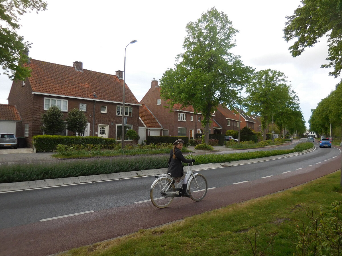 Тихая уютная улочка в Лиссе — с разделительной полосой и велодорожками, тротуар для пешеходов — отдельно.