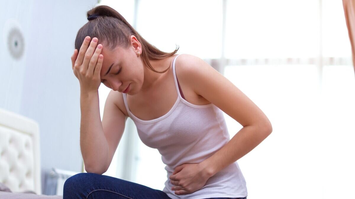    Девушка держится за живот© Depositphotos / goffkein