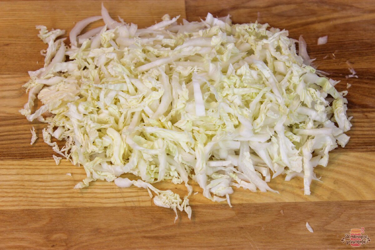 С пекинской капусты удалить верхние, вялые листья, затем половину вилка капусты тонко порезать. 