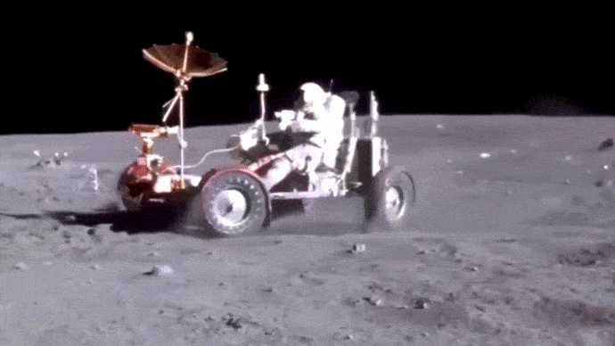 Переднее колесо проехало, а заднее провалилось в яму.   Выброс пыли в сторону зрителя.