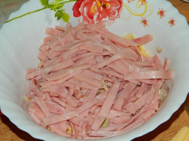 Куриное мясо режем на кусочки, добавляем тертый сыр.  Режем соломкой ветчину и добавляем в салат.
