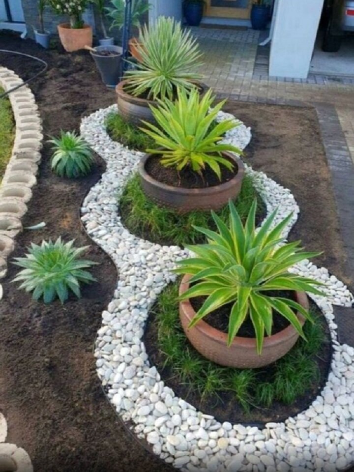 Цветы в горшках, выставленные на газоне.