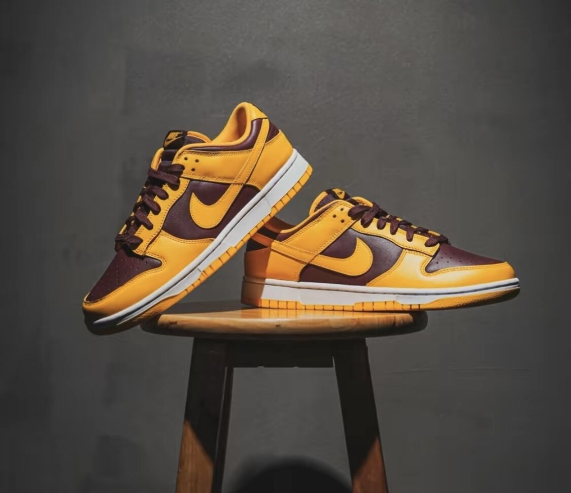Изображена пара Nike Dunk Low Retro «University Gold»