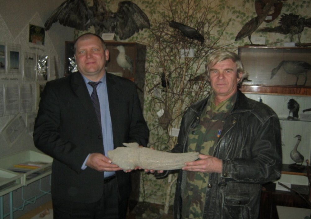 Директор Бродокалмакской средней школы А.В. Паташенко и палеонтолог В.И. Юрин с фрагментом рога бизона в школьном краеведческом музее.