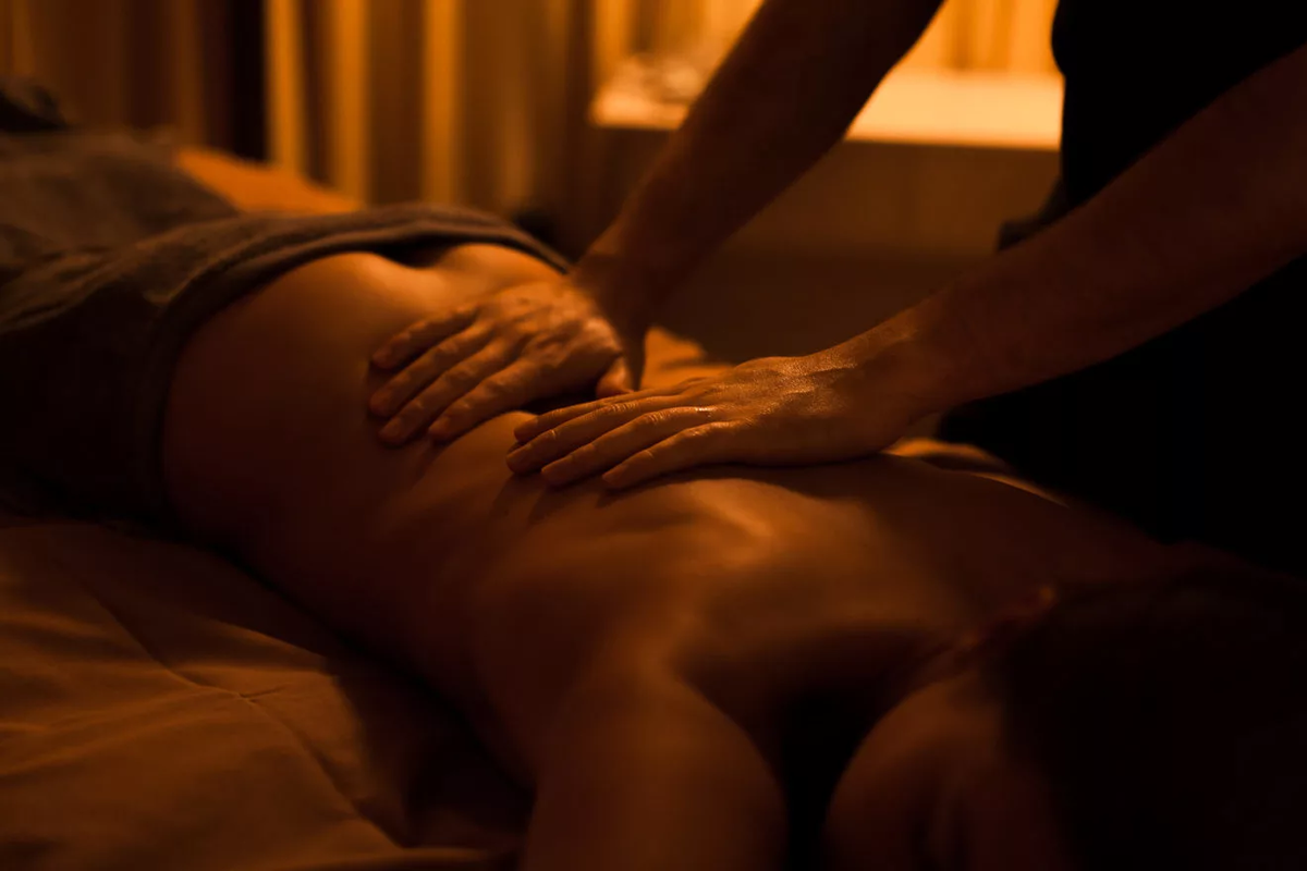 Женщина делает мужчине массаж.