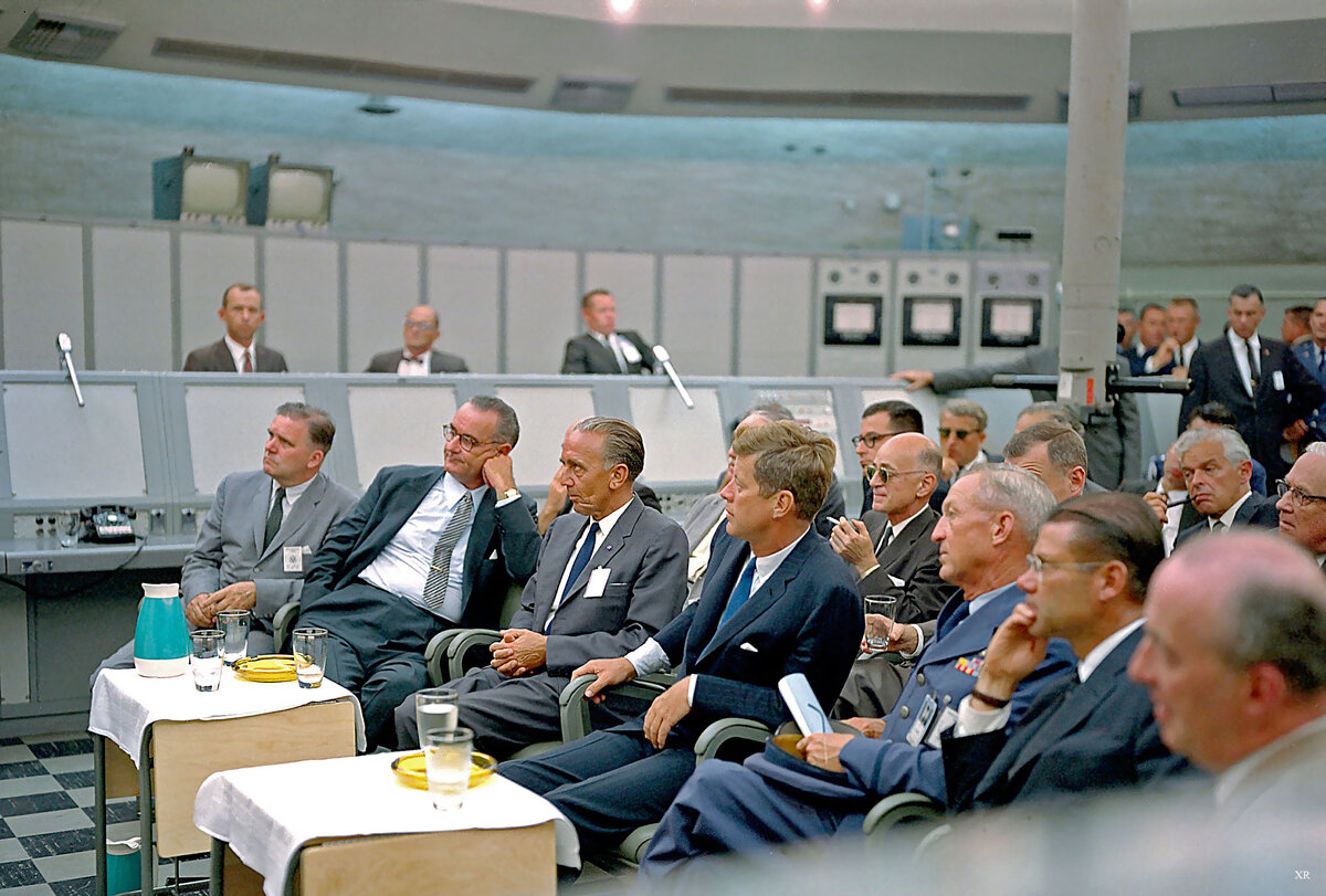 Джон Кеннеди во время ракетных испытаний на мысе Канаверал.                                                   In this image from 1962, Kennedy attends a briefing given by Major Rocco Petrone during a tour of Blockhouse 34 at the Cape Canaveral Missile Test Annex. Also in attendance are Vice-President Lyndon Johnson and Secretary of Defense Robert McNamara.