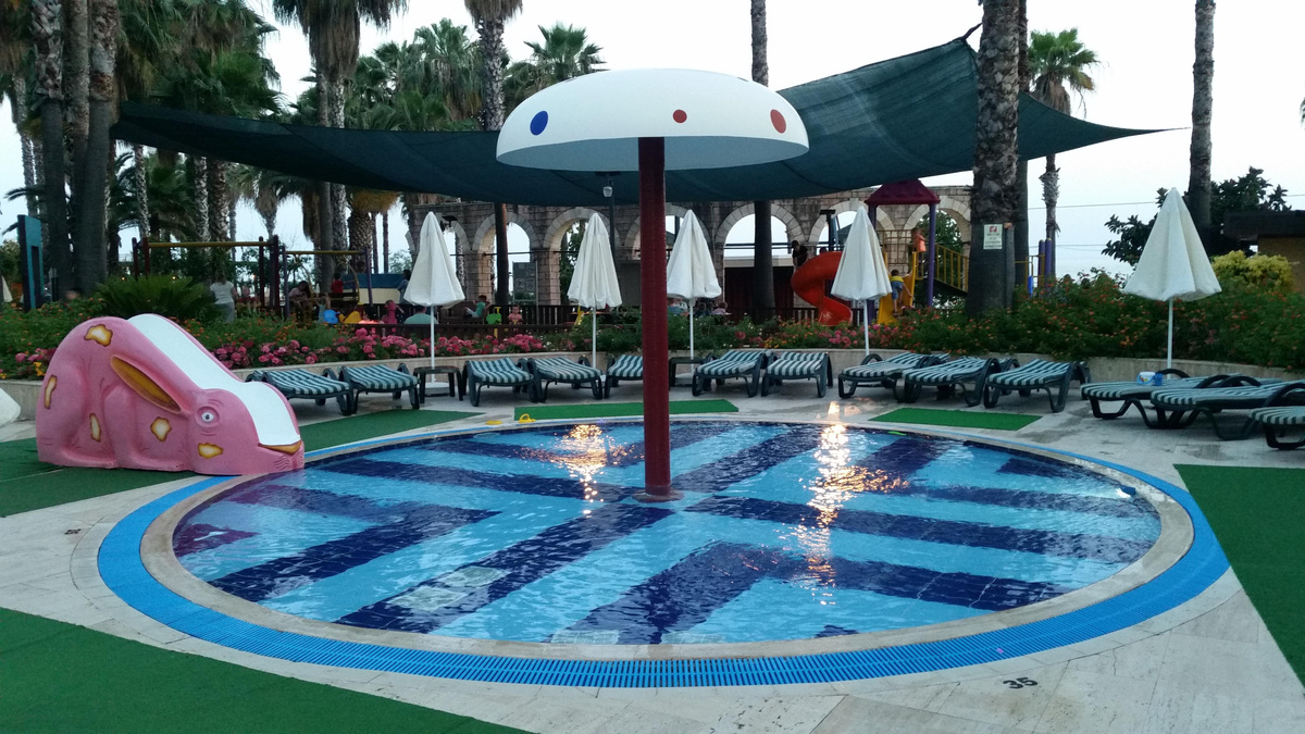 бассейн для малышей, позади него находится детская площадка 